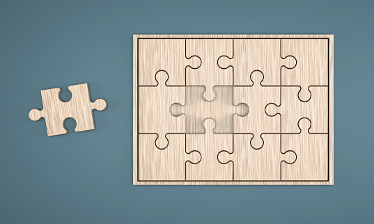 Wooden Jigsaw Puzzle box on the blue background. Teamwork concept.