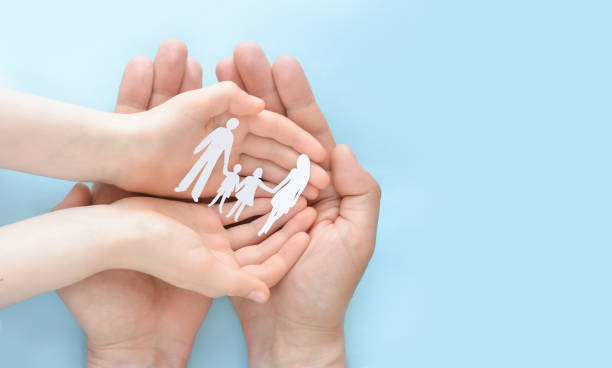 Hands holding paper family . The concept of family protection and care, charity support for the homeless, world mental health day, international family day, lockdown concept . Copy space Hands holding paper family . The concept of family protection and care, charity support for the homeless, world mental health day, international family day, lockdown concept . Copy space annual event photos stock pictures, royalty-free photos & images