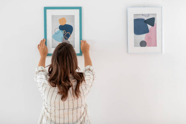 istock woman decorating home with picture in frame 1401527988