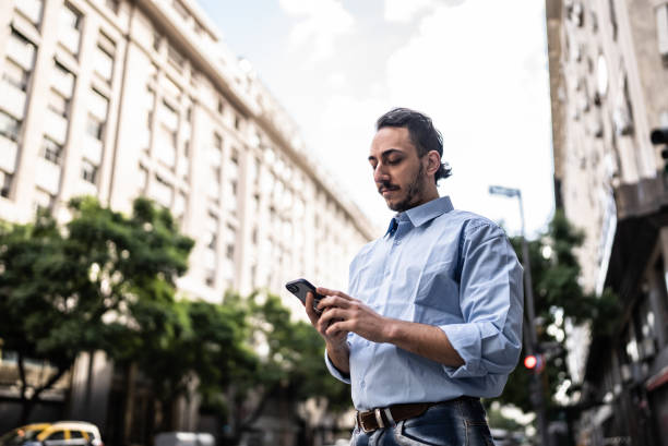 istock Young man using the mobile phone on the street 1401528739