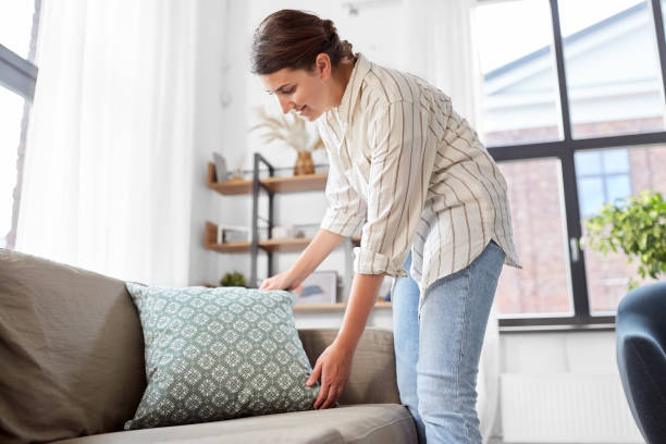 istock woman arranging cushions at home 1401528747