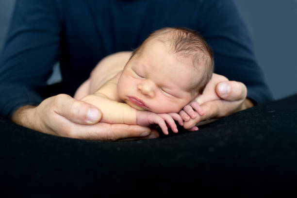 istock Beautiful baby boy, sleeping peacefully in fathers hands, infant sleeping 1401528794