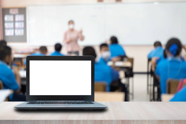istock Computer on the table, blur image of the children classroom 1401528947