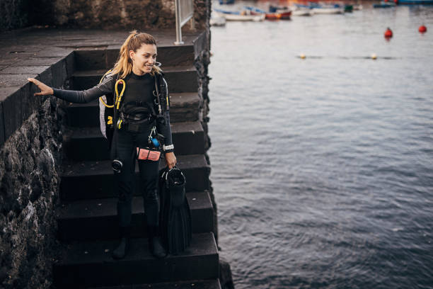 istock Young woman diver going in the sea to dive and explore sea bottom 1401528984