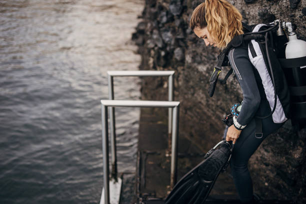 istock Young woman diver going in the sea to dive and explore sea bottom 1401529113