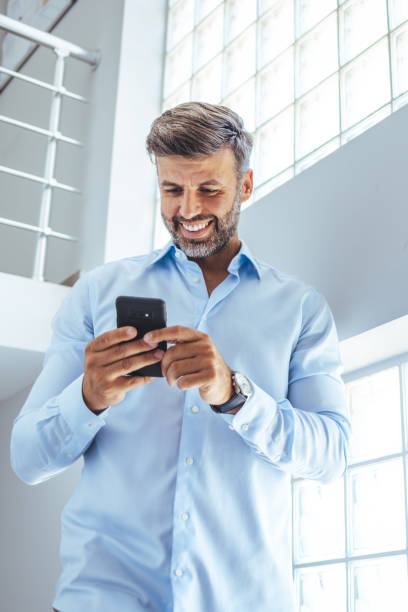 istock Happy mature business man using phone walking on commute commuting to work 1401529356