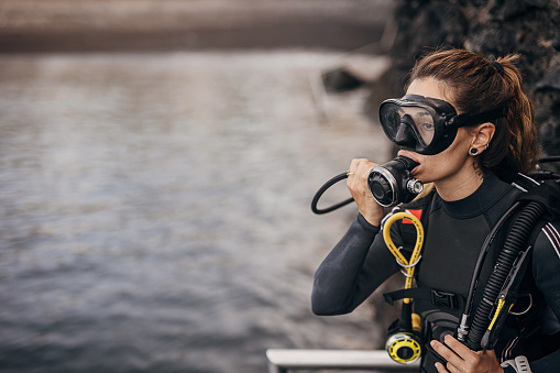 Woman diver preparing for diving in the sea