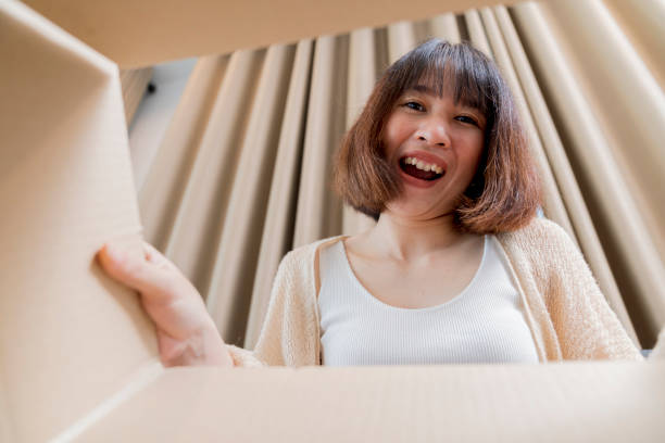 istock A cute smiling woman opened the box and looked inside 1401529999