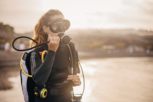 Woman diver preparing for diving in the sea