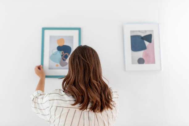 istock woman decorating home with picture in frame 1401530046