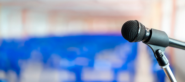 Microphone on abstract blurred of speech in seminar room or speaking conference hall light, Event Background