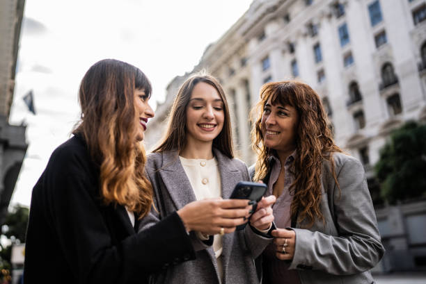 istock Women using smartphone together outdoors 1401531364