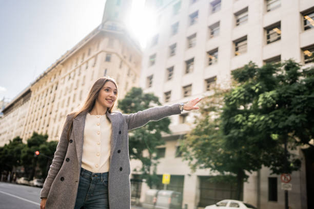 istock Young businesswoman gesturing to get a cab 1401531372
