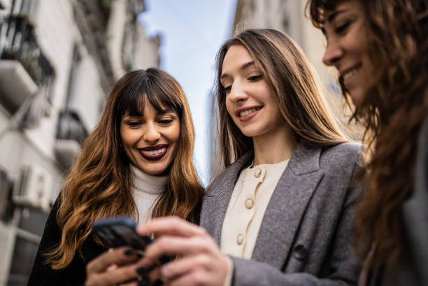 istock Women using smartphone together outdoors 1401531406