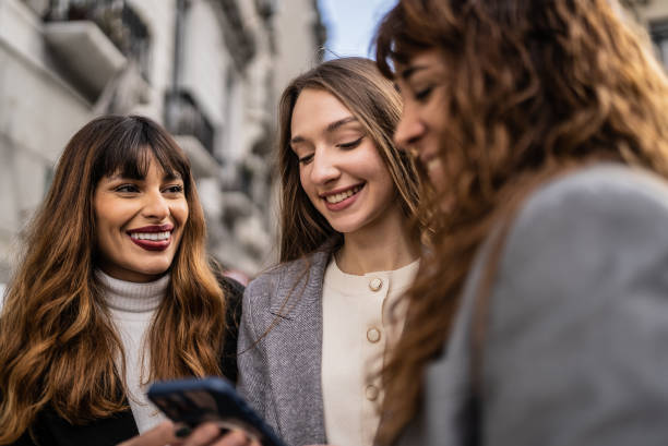 istock Women using smartphone together outdoors 1401531410