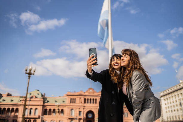 women taking selfies on the mobile phone on the street - buenos aires stockfoto's en -beelden