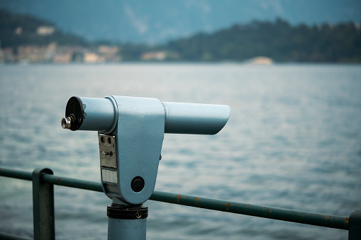 Coin operated monocular on the edge of a lake.