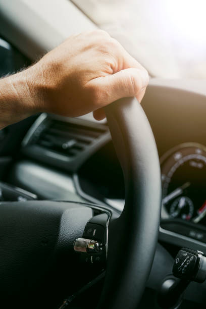istock Male hands on a car's steering wheel 1401533047