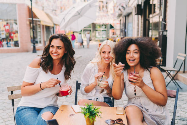 istock Women on summer trip talking at sidewalk cafe 1401533105