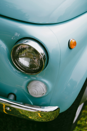 Color close up of a cyan vintage car headlight and turn signal.