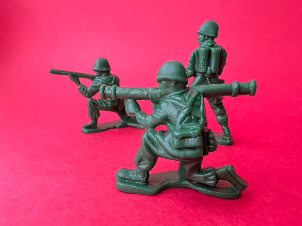 istock Three soldiers are holding a gun toward the enemy (red background), a war concept. 1401533370