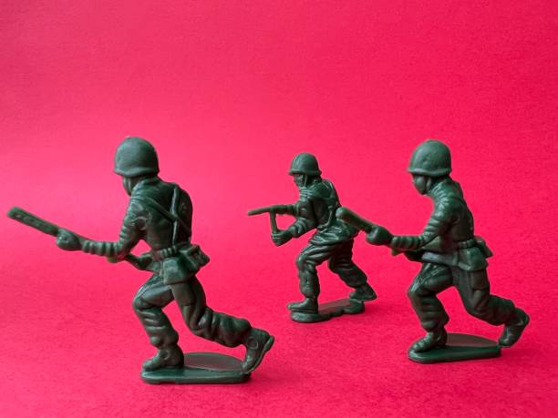 istock Three soldiers are holding a gun toward the enemy (red background), a war concept. 1401533382