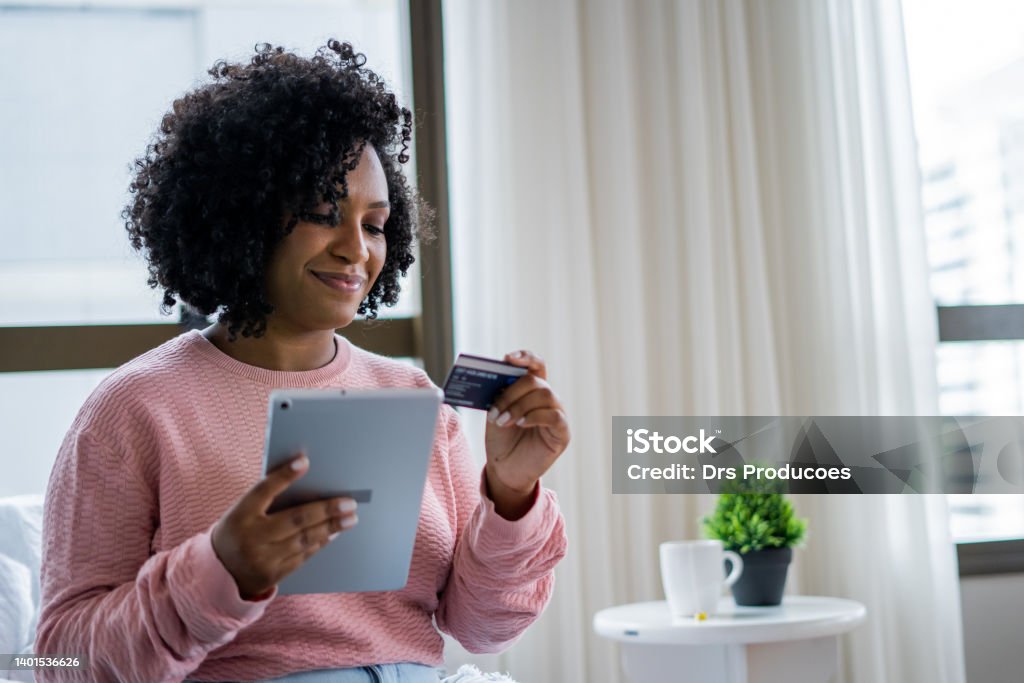 Black woman shopping online Black woman shopping online using a digital tablet Credit Card Stock Photo