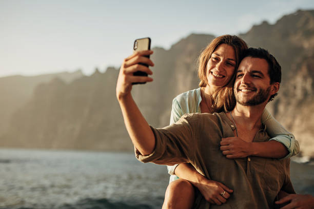 istock Couple is having fun and taking a selfie on the beach at sunset 1401537451