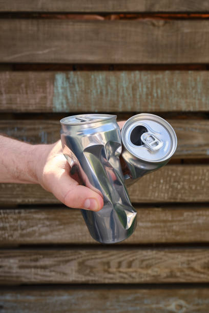 istock Crumpled tin can in hand. Recyclable material. Environmental protection. Zero waste. Used beverage containers 1401540723