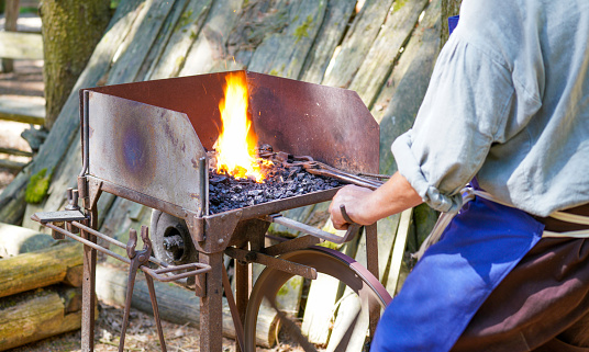 Blacksmith with red-hot iron at work