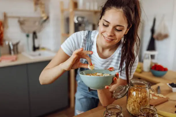 Young woman tasting breakfast that she just made