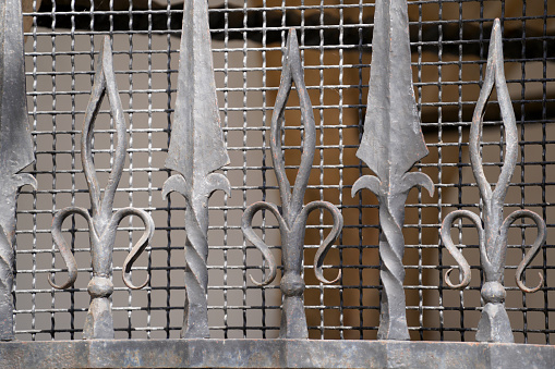 Ornate and beautiful wrought iron fence gate painted scarlet red and gold