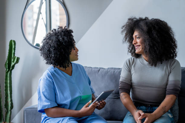 Black nurse consulting trans woman at home Black nurse consulting trans woman at home transgender stock pictures, royalty-free photos & images