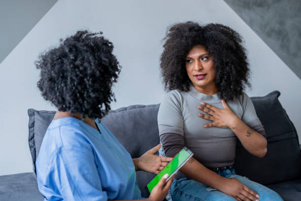 Black nurse consulting trans woman at home Black nurse consulting trans woman at home transgender stock pictures, royalty-free photos & images