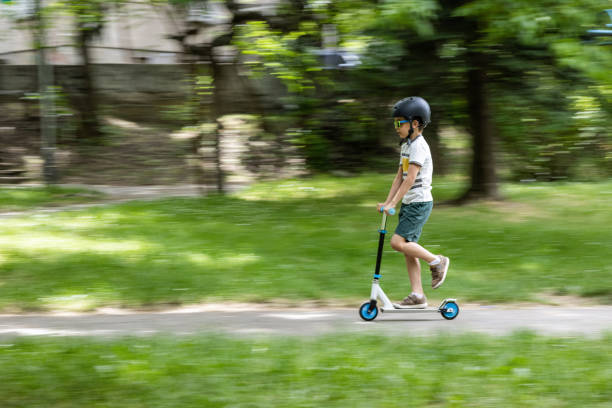 istock Kid riding push scooter in the park 1401542474