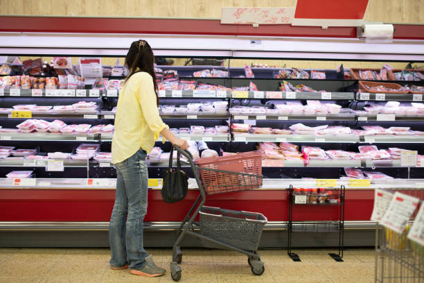 eine frau, die in einem supermarkt einkauft - inflation stock-fotos und bilder