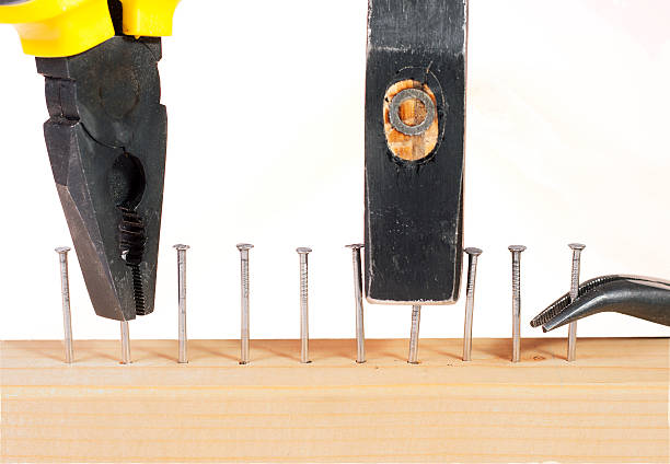 istock Pliers and hammer with nails in wooden plank. 140154360