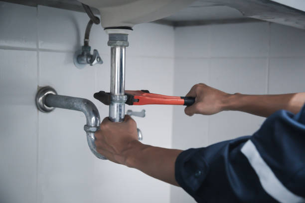 istock Male Plumber Using Wrench To Fix Leaking Sink In Home Bathroom. 1401543825