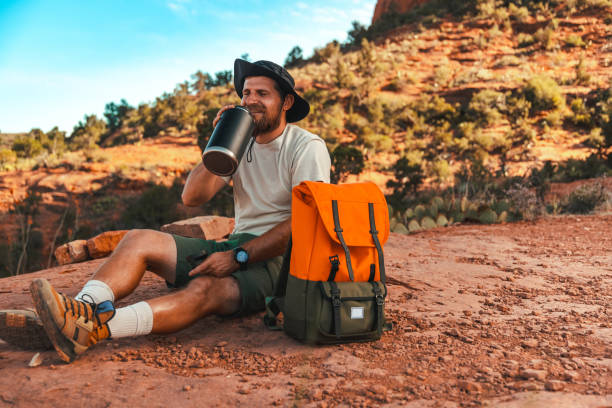 A man with a backpack in canyon in southwest America resting and enjoying the view