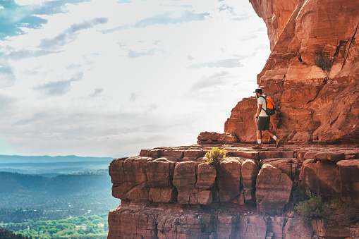 Woman standing next to Thor's Hammer hoodoo on top of  mountain looking at beautiful view. Bryce Canyon National Park, Utah, USA