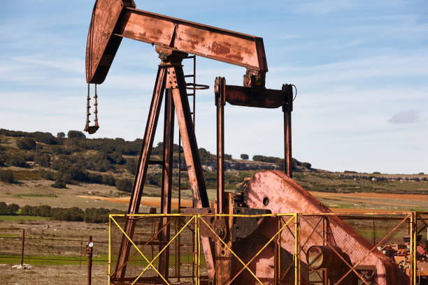 Oil pumping machine. Pump jack. Petroleum extraction. Global warming stock photo