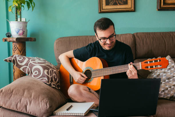 istock Man learns to play guitar from home 1401550394