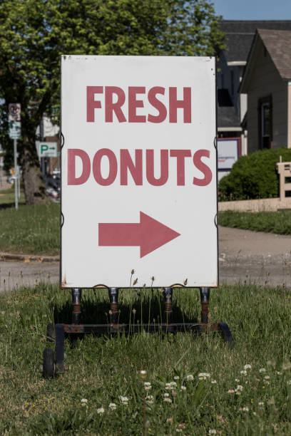 istock Fresh Donuts sign with an arrow - subtitled How To Catch a Cop. 1401552279