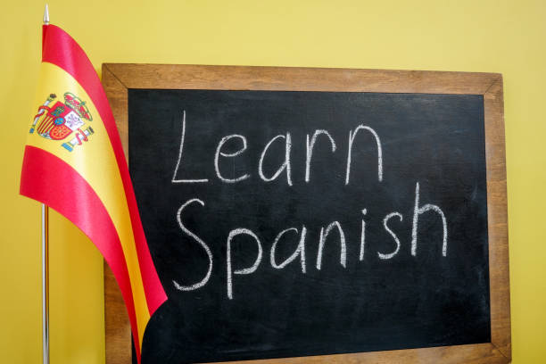 istock Learn Spanish sign on the blackboard and flag. 1401554017