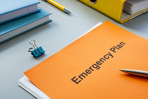 An Emergency plan near a yellow folder and pen.