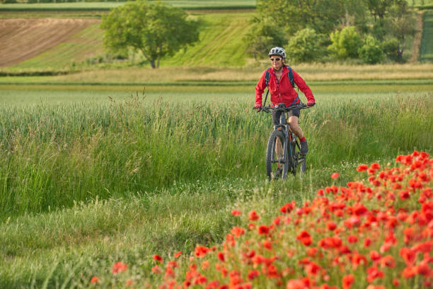 istock woman on electric bicycle  between blooming poppies 1401557636