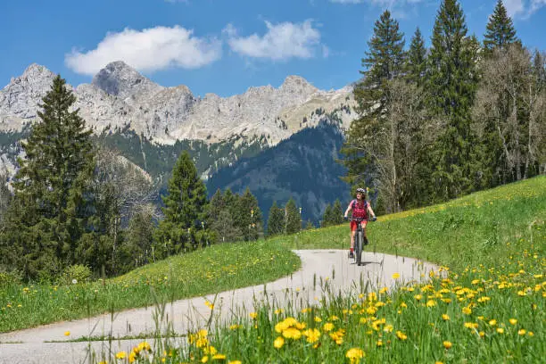 nice senior woman riding her electric mountain bike in the Lech Valley mountains near Reutte in Tirol, Austria
