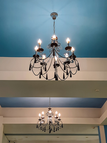 Chandelier with lamps in the form of candles on a blue ceiling
