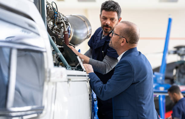 istock Aeronautical Engineer And Helicopter Owner Talking In Hangar 1401560869