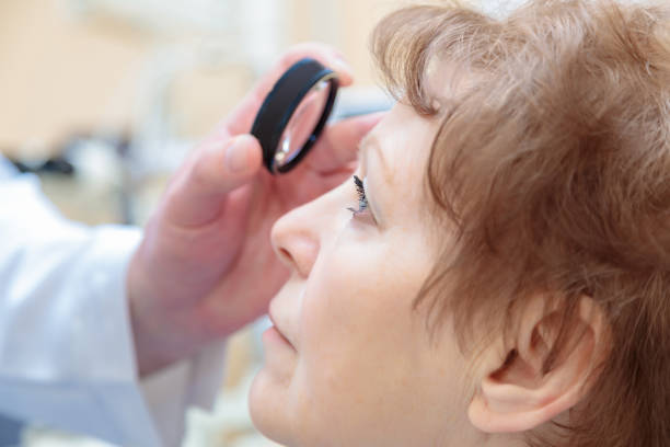 A male ophthalmologist checks the eyesight of an adult woman with a binocular ophthalmoscope A male ophthalmologist checks the eyesight of an adult woman with a binocular ophthalmoscope. myopia photos stock pictures, royalty-free photos & images